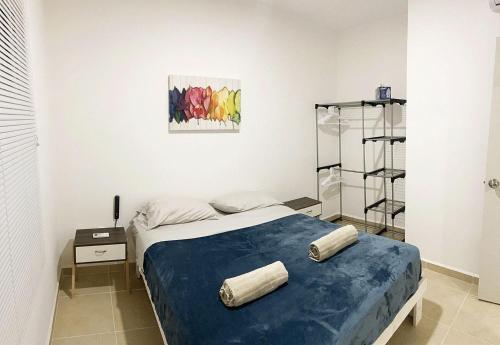 a bedroom with a bed with a blue blanket at Angels Beach Condo con Piscina, Parking y Parque in Playa del Carmen
