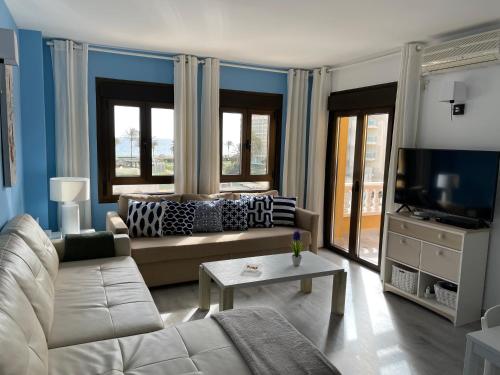 sala de estar con sofá y TV en Apartamentos Roquetas Beach, en Roquetas de Mar