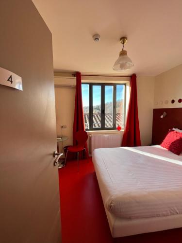 a bedroom with a bed and a window with red curtains at Le Vinois in Caillac