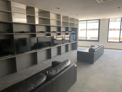 a living room with couches and a flat screen tv at Green Life Full Amenities in Punta del Este