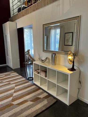 a living room with a white cabinet and a mirror at BLB Loft Luxury House in Villenave-dʼOrnon