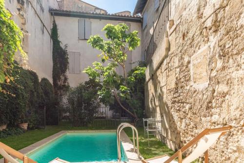 - une piscine dans une cour à côté d'un bâtiment dans l'établissement Private Mansion, completely renovated with swimming pool, in historical center, à Arles