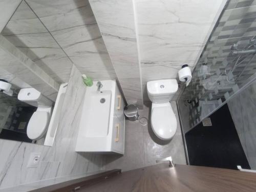 y baño con 2 aseos, lavamanos y espejo. en Mini Loft en Becerril de la Sierra