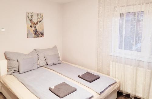 1 cama con 2 toallas en un dormitorio en Indira Vendégház en Nyíregyháza