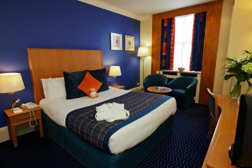a hotel room with a large bed and a chair at The Midland Hotel in Bradford