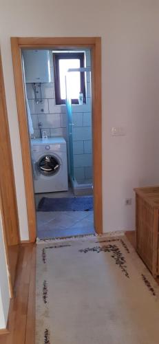 a bathroom with a sink and a washing machine at Apartmani Amira Trebinje in Trebinje