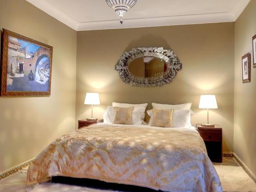 a bedroom with a large bed and a mirror at Riad Dar Chacha in Marrakech