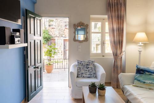 een woonkamer met een witte bank en een raam bij Maisonette Elena in Longós