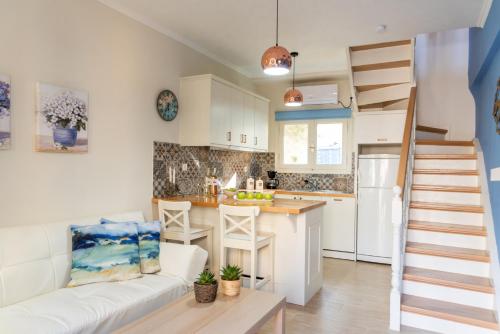 een woonkamer met een witte bank en een keuken bij Maisonette Elena in Longós