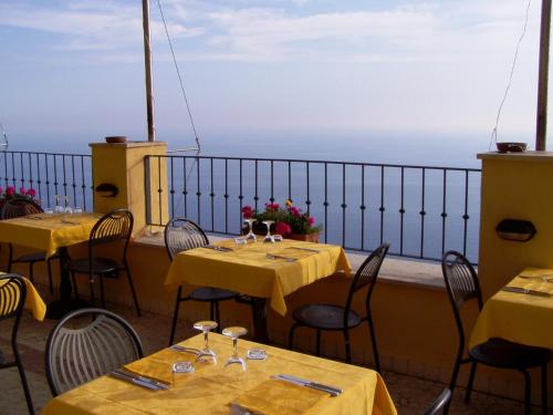 a dining room table with chairs and umbrellas at Il Borgo Di Campi in Riomaggiore