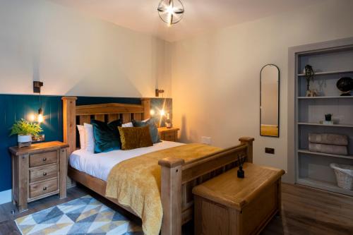 a bedroom with a large wooden bed with blue pillows at Station View, Dunblane in Dunblane