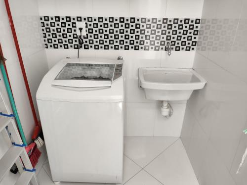 a white bathroom with a toilet and a sink at Apartamento a 100 metros da Praia do Forte - Algodoal 206 in Cabo Frio