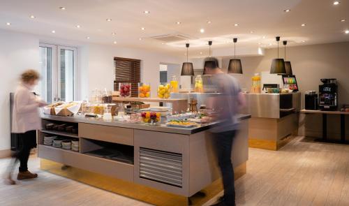 zwei Personen stehen in einer Küche und bereiten Essen zu in der Unterkunft Hotel Stachus in München