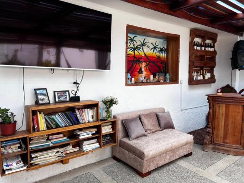 a living room with a couch and a book shelf at Hostel las Palmas in Vilcabamba