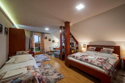 1 dormitorio con 2 camas y sala de estar en Baglyas Vendégház, en Edelény