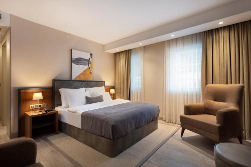 Habitación de hotel con cama y silla en Buem Hotel Koşuyolu en Estambul