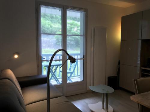 a living room with a couch and a window at T2 +alcove, récent 4/5 pers. Parking. Balcon. Wifi in Cauterets