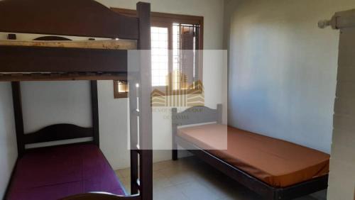 a room with two bunk beds and a window at Casa Residencial Duque de Caxias in Arroio do Sal