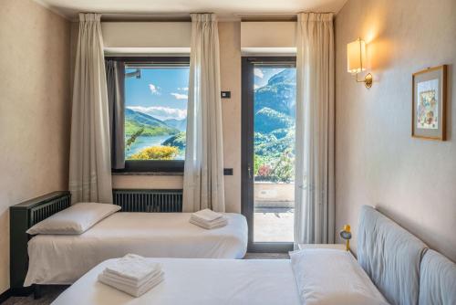 Cette chambre comprend 2 lits et une fenêtre. dans l'établissement VILLA SISSI - PARADISO SULLE DOLOMITI, à Molveno