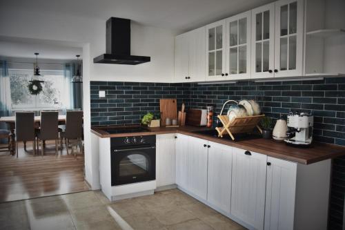 a kitchen with white cabinets and a stove top oven at Oto Widoki in Szklarska Poręba