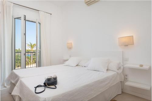 a white bed with a black purse on top of it at NEW! Villa ESPERANZA, Can Marilla, Front Sea View, Pool, AC, BBQ in Portocolom