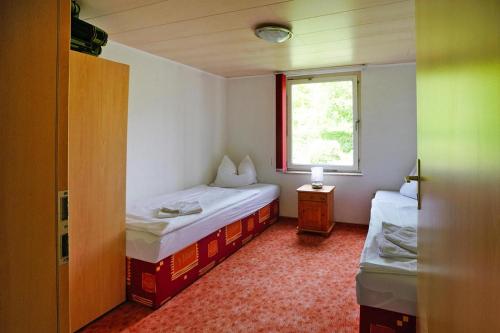 a small room with two beds and a window at Ferienhaus Eldeblick direkt am Eldeufer in Parchim in Parchim