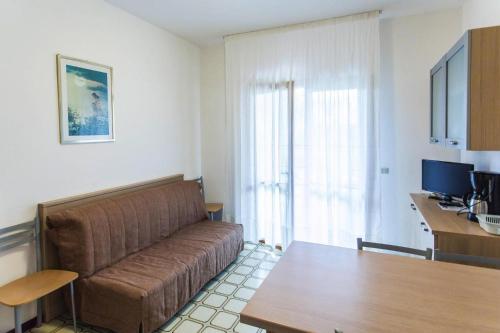 un soggiorno con divano e tavolo di Residence Villaggio Sole B, Bibione Spiaggia a Bibione