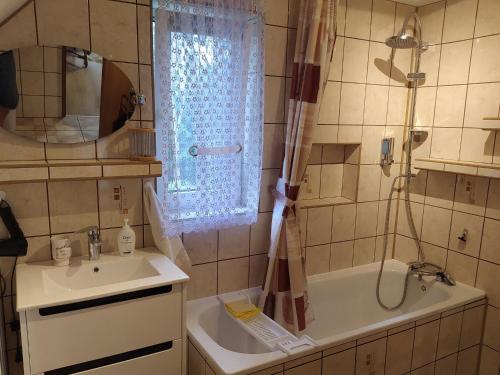 La salle de bains est pourvue d'un lavabo, d'une douche et d'une baignoire. dans l'établissement holiday home, Morzyczyn, à Morzyczyn