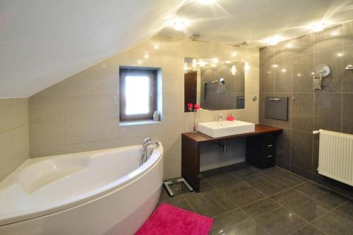 a bathroom with a large tub and a sink at holiday home, Kolobrzeg in Kołobrzeg
