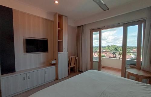 a bedroom with a large bed and a large window at Core Hotel Benoa in Nusa Dua