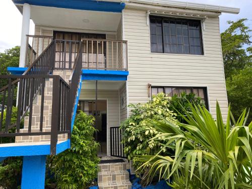 a house with a blue staircase in front of it at Posada Turistica el Swampito in San Andrés