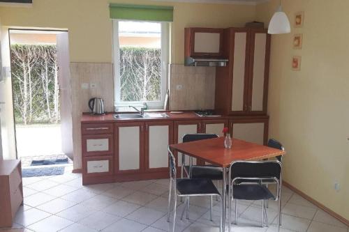 a kitchen with a wooden table and chairs in a room at Holiday homes, Niechorze in Niechorze