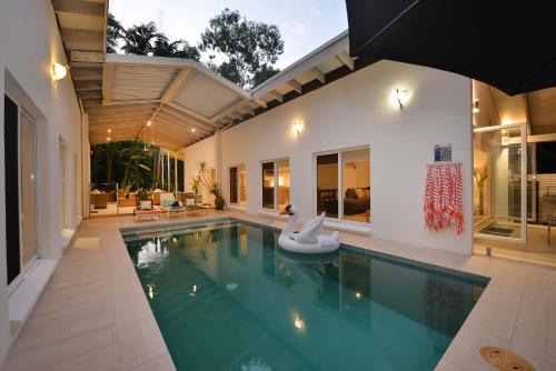 una piscina cubierta con una casa en Pavilions in the Palms Heated Pool Short Path To Beach Five Bedrooms Sleeps 14, en Port Douglas