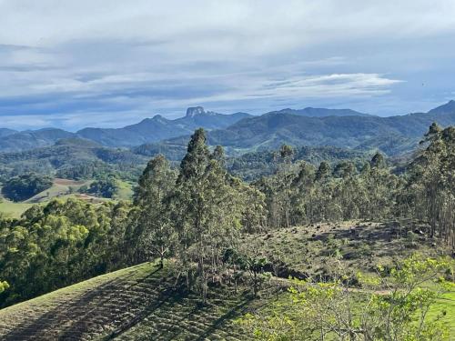 a view of a hill with mountains in the background at Chalé Terrarum in Santo Antônio do Pinhal