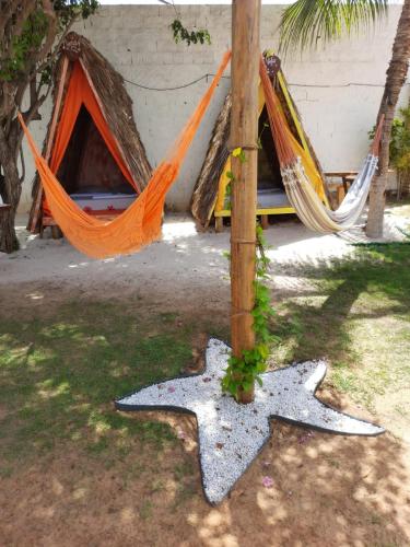 a couple of hammocks in front of a house at POUSADA CENÁRIO IDEAL in Icapuí