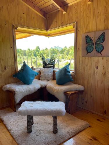 a room with a window and a room with a butterfly on the wall at Cabañas Kuela in Puerto Varas