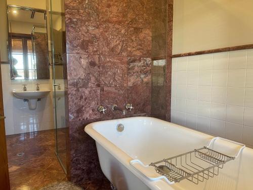 un baño con bañera y lavabo en Yarrabandai Creek Homestead, en Ootha