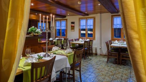 a dining room with tables and chairs and windows at Swiss Lodge Joopi in Reckingen - Gluringen