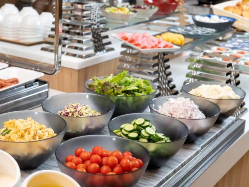 a buffet line with bowls of different types of food at HOTEL MYSTAYS Soga in Chiba