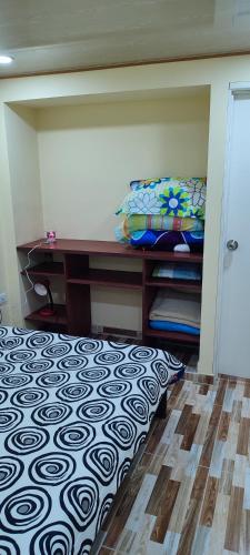 a bedroom with a bed and a desk and a floor at Aparta estudio cerca al aeropuerto espectacular in Bogotá