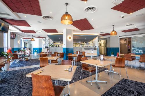 a dining room with tables and chairs in a restaurant at Royal Hotel by Nightcap Social in Melbourne