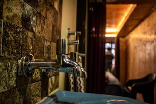 a bathroom sink with a faucet on a brick wall at Deodar Homestay Dakbangla-kufri in Shimla