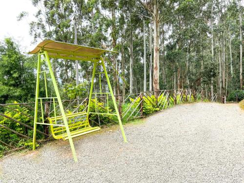 a small yellow structure sitting in the middle of a forest at Castillo De Woods , The Private Luxury Villa , 8 BHK, Vattavada in Kottakamboor