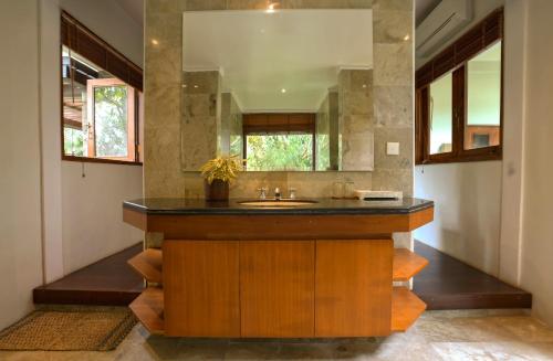 a bathroom with a sink and a mirror at Umah Lawas Villa Ubud in Ubud