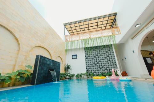 an indoor swimming pool in a building with a swimming pool at Villa Ruang Rindu Malioboro in Sentool