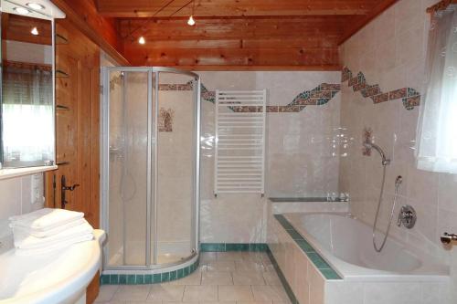 ein Badezimmer mit einer Dusche, einer Badewanne und einem WC in der Unterkunft Chalet Rabl, Westendorf in Westendorf