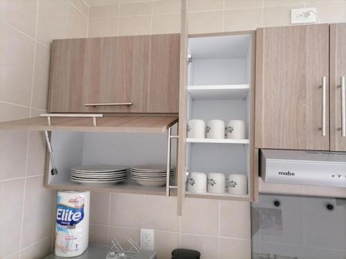 una cucina con mobili in legno, piatti e stoviglie di Departamento Amplio Pb Ubicacin, Seguridad a Querétaro