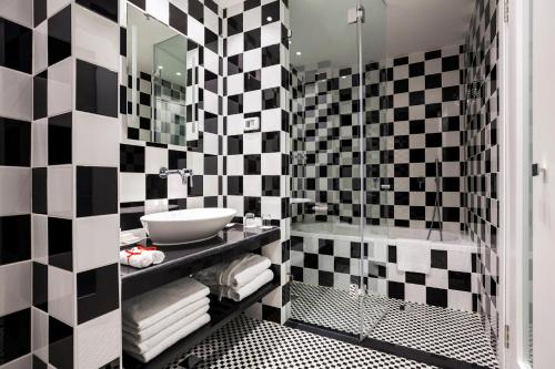 a bathroom with a black and white checkered wall at Harmony Hotel - an Atlas Boutique Hotel in Jerusalem