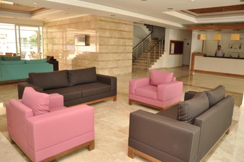 a lobby with two couches and pink chairs at Almera Park Apart Hotel in Alanya