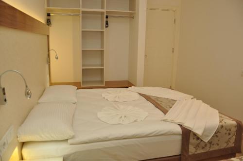 a bedroom with a bed with white sheets at Almera Park Apart Hotel in Alanya